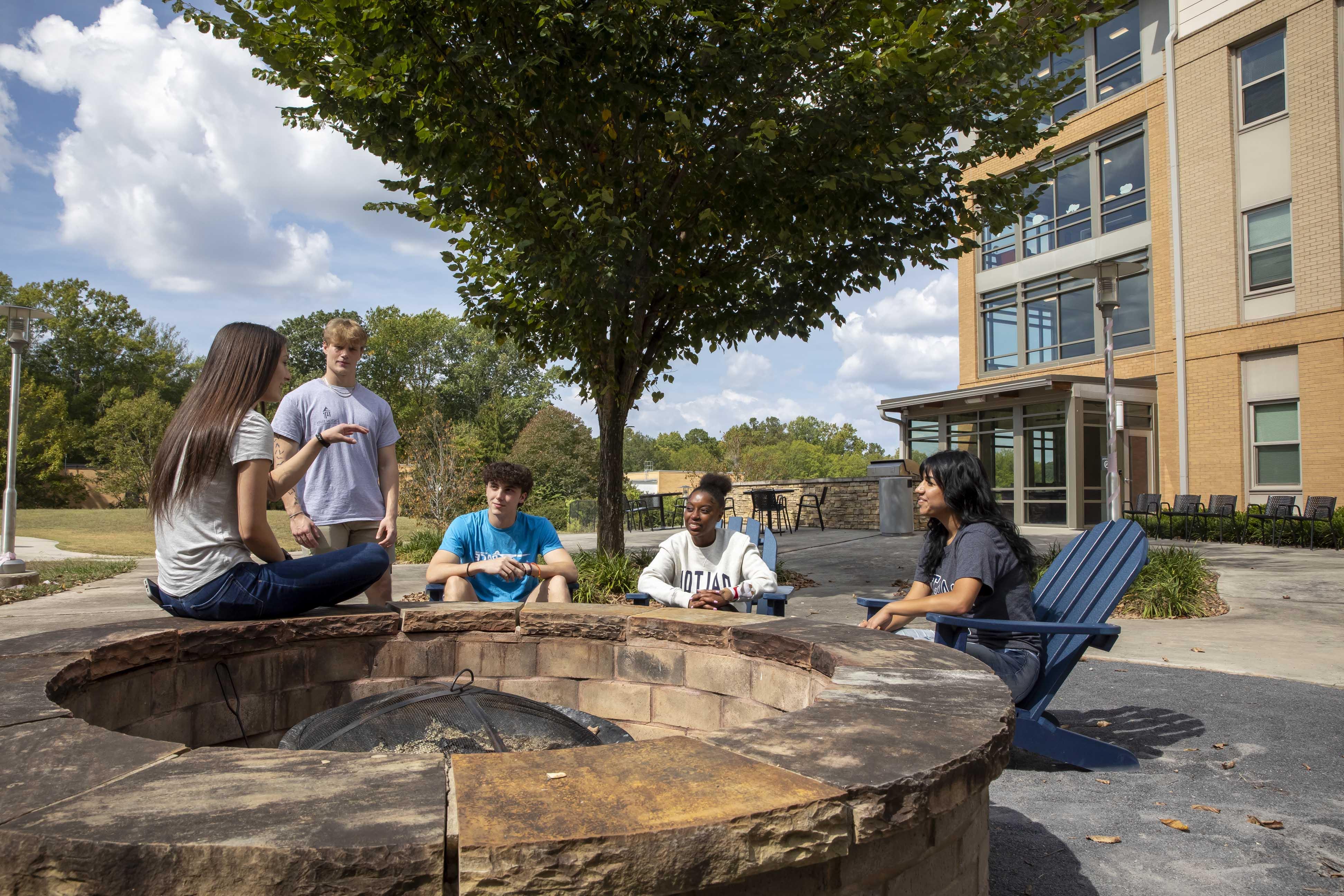 Students hanging out around Mashburn firepit